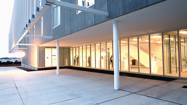 Photo of the FADS building with interior lights shining through a wall of windows