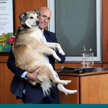Gary Lezak and Sunny the Weather Dog at the Journalism department's Headline Award luncheon, after being presented the award by Journalism dept. chair Gretchen Thum