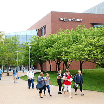 students walking in front of the Regnier center in the spring time