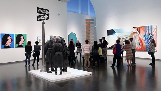 A small crowd of people listen to a presenter discuss art at the Nelson Atkins Museum of Art.