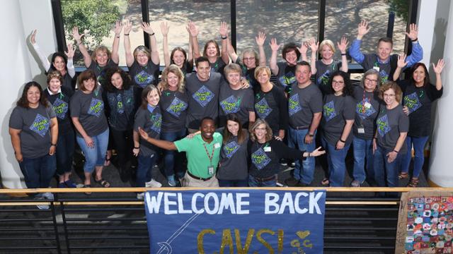 JCCC admissions staff gathered around Braden Decker waving at the camera