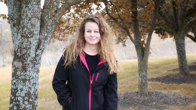 Echo Tyler standing under trees with a fall foliage