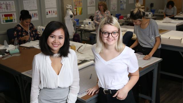 JCCC students Rebekah Lux and Nguyet Nguyen posing in a fashion design classroom