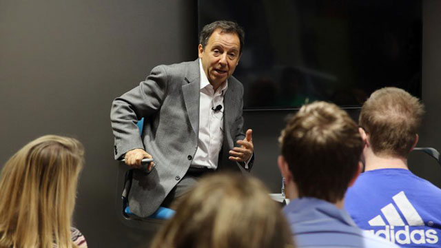 Ron Suskind in a chair addressing the Kansas Autism Conference