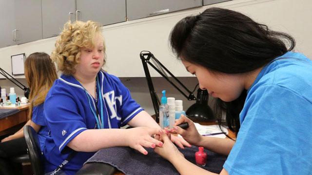 Cosmetology student dresses the hair of a prom-goer.