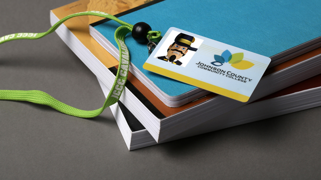 Student ID card draped across a stack of books on a table. It is jean Claude Cavalier's ID card.