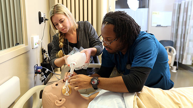 Respiratory care students learn using a manikin