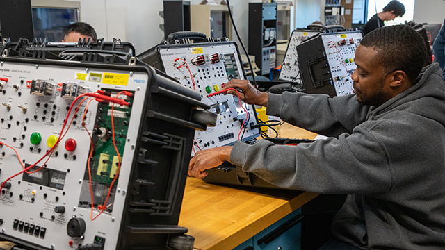 Student working on a circuit board in the AET lab