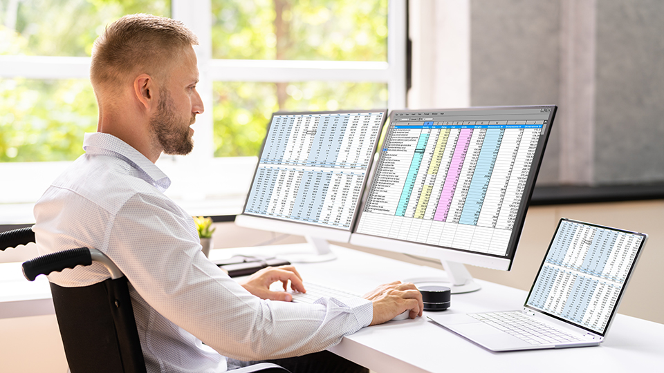 a man sitting at a computer entering medical codes