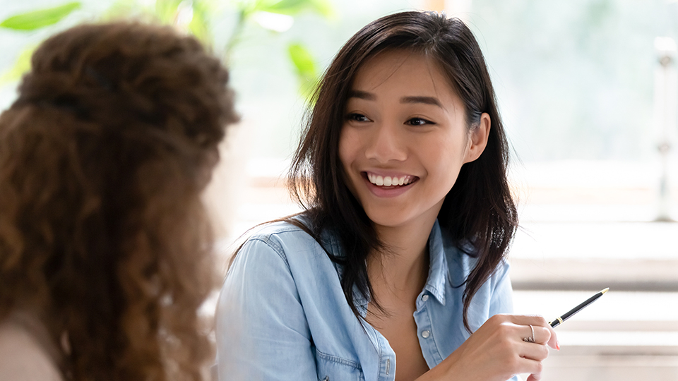 Two students smile while conversing.