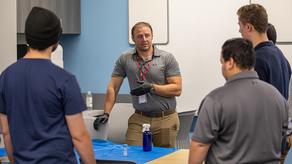An instructor talks to a group of students.