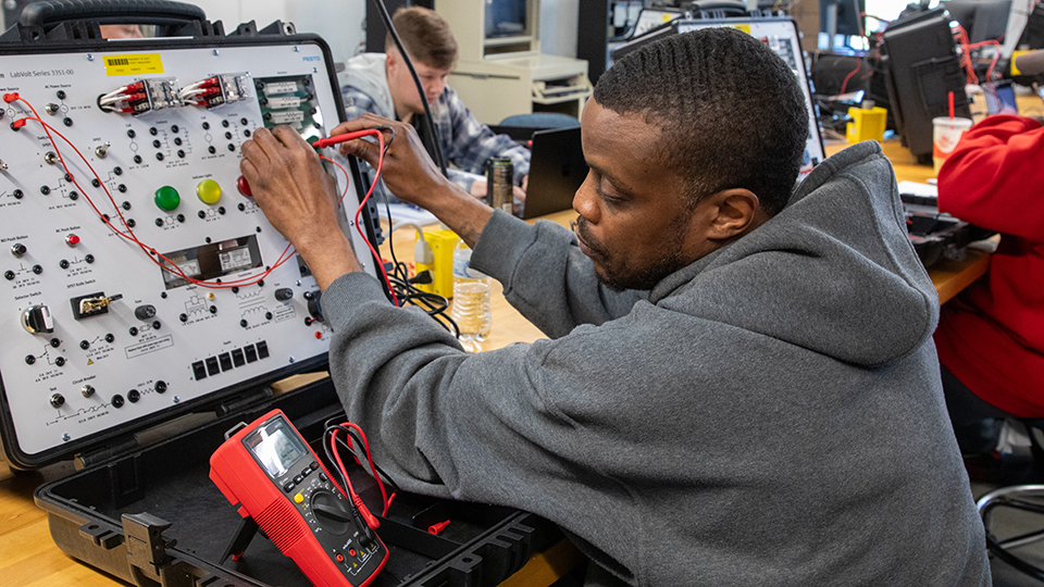 Student working with electronic technology equipment