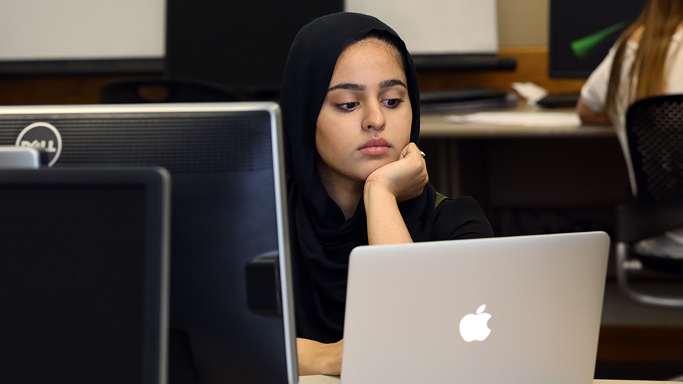 A student stares at a computer screen.