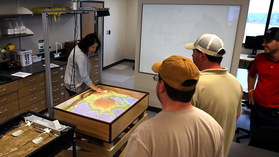 students demonstrating the use of lab equipment in for geoscience