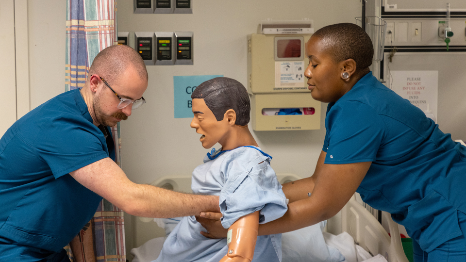 a group of JCCC nursing students listen intently to an instructor