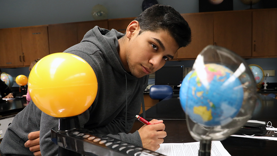 Student looking at a model of planets