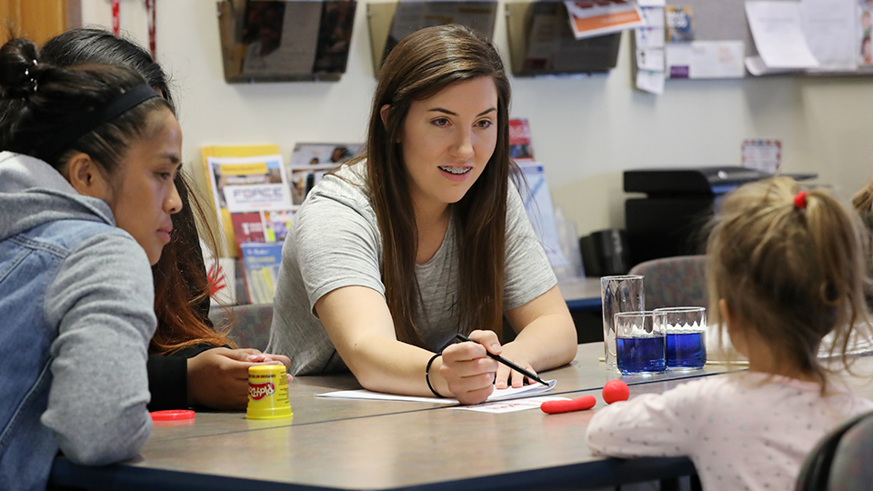 A student goes over instructions with a young child.