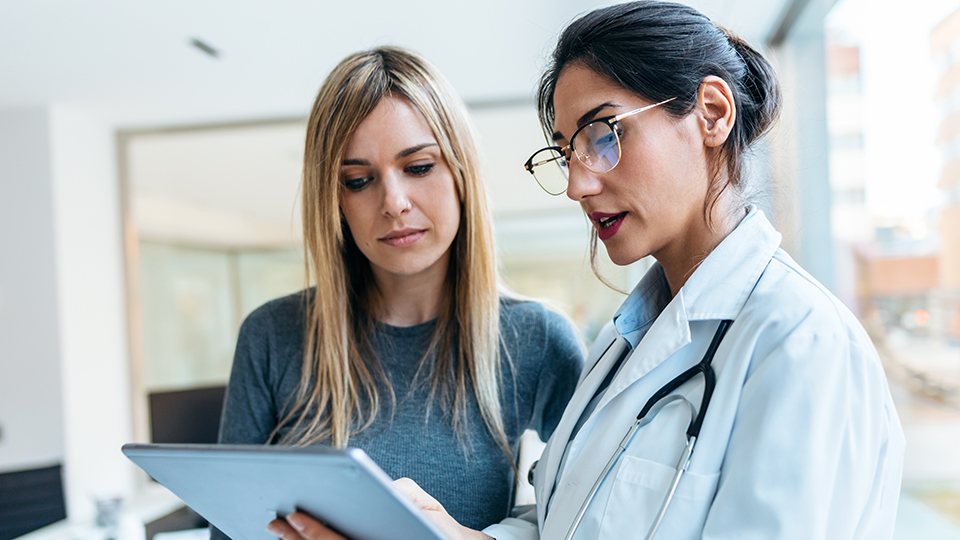 a doctor and a woman look at a patient's chart