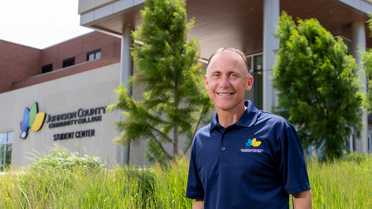 Dr. Tony Miksa standing in front of the Student Center. He's wearing a JCCC polo shirt.