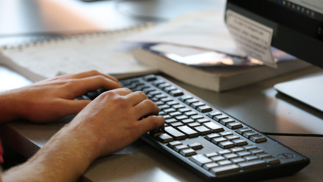 Student hands on a keyboard searching on a computer.