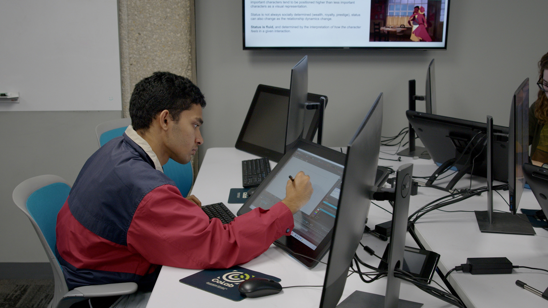 Student in an animation class drawing with a stylus on a tablet