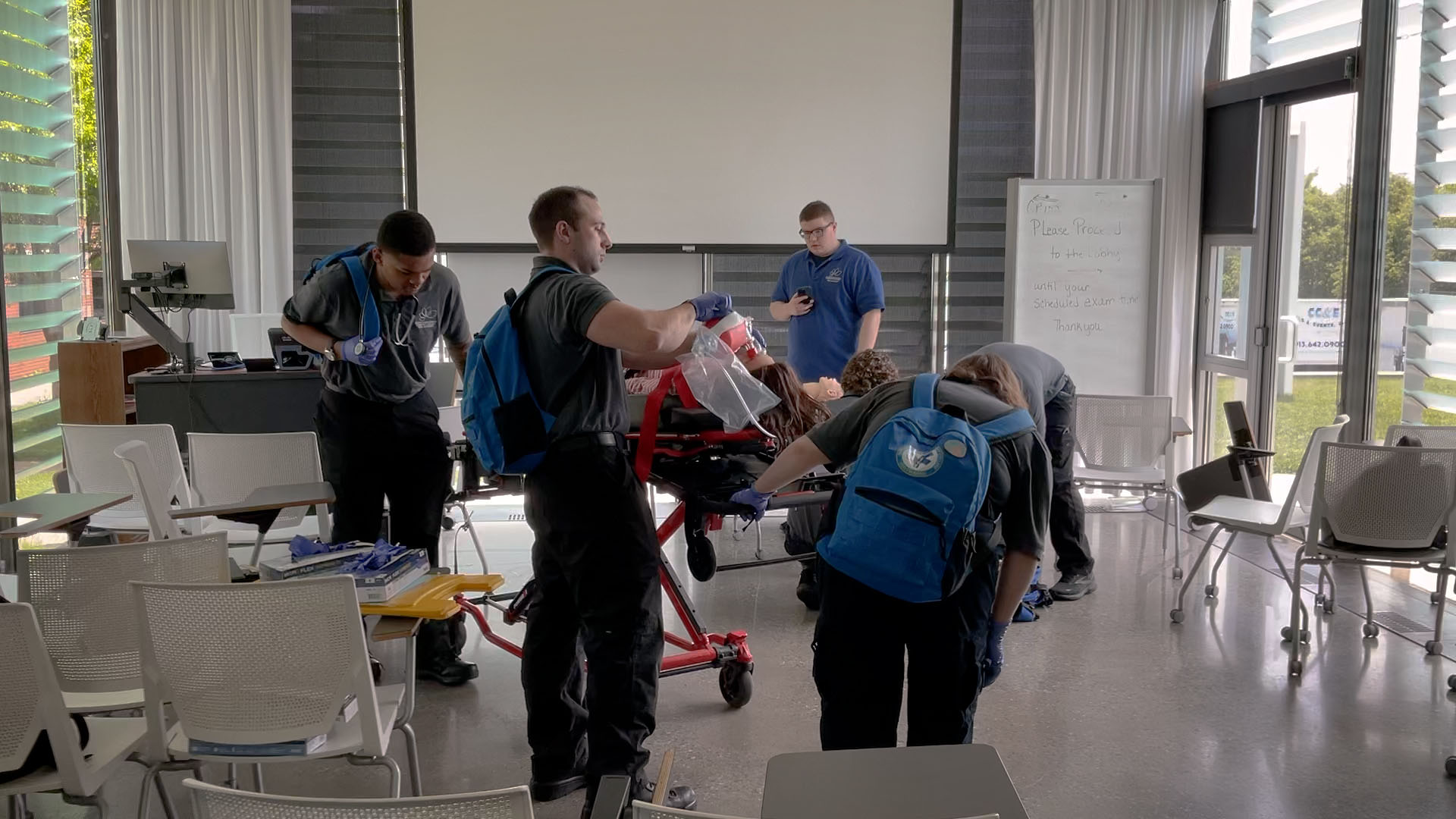 Paramedic students practicing with a patient on a gurney