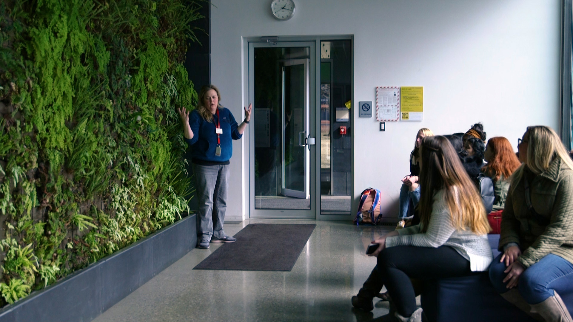 Faculty lecturing in front of the living wall in Galileo's Pavilion