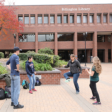 Students play hackey sack outside the Billington Library on the main JCCC campus.