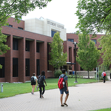 Students walk outside the Student Center building on the JCCC main campus.