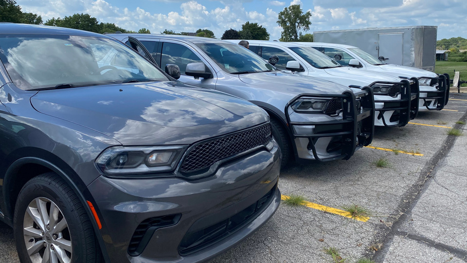 a row of police vehicles parked in a lot