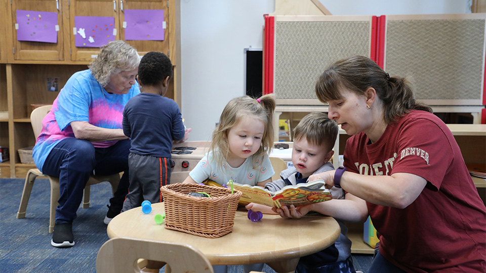 two preschool teachers reading to children