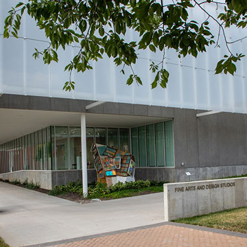 Exterior of the Fine Arts and Design Studios with a sculpture by the front door
