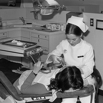 A dental hygiene student treats a patient.