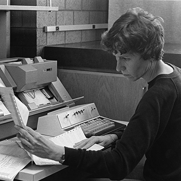 A woman in the business office looks over paperwork.