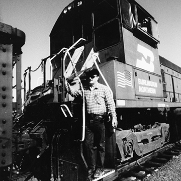 A man stands on a Burlington Northern Railroad car at JCCC.