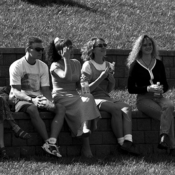 Students sit on a retaining wall at JCCC.