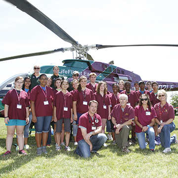 Healthcare students pose by a LifeFlight helicopter.