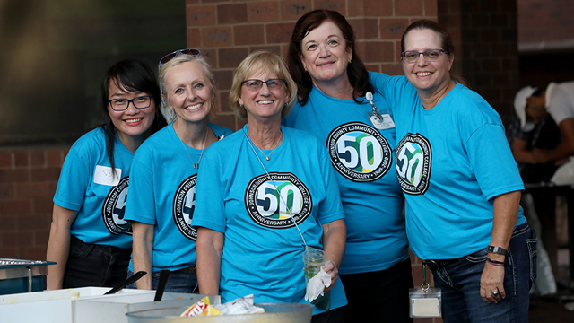 A group of five JCCC employees wearing JCCC shirts and smiling