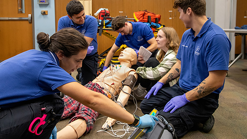Paramedics working with a simulation dummy as a patient