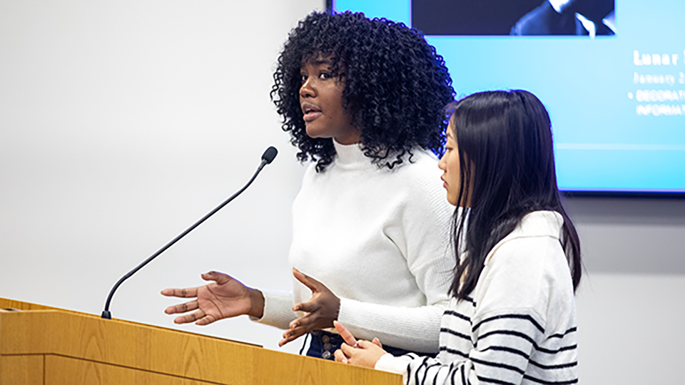 Two students giving a presentation at a podium