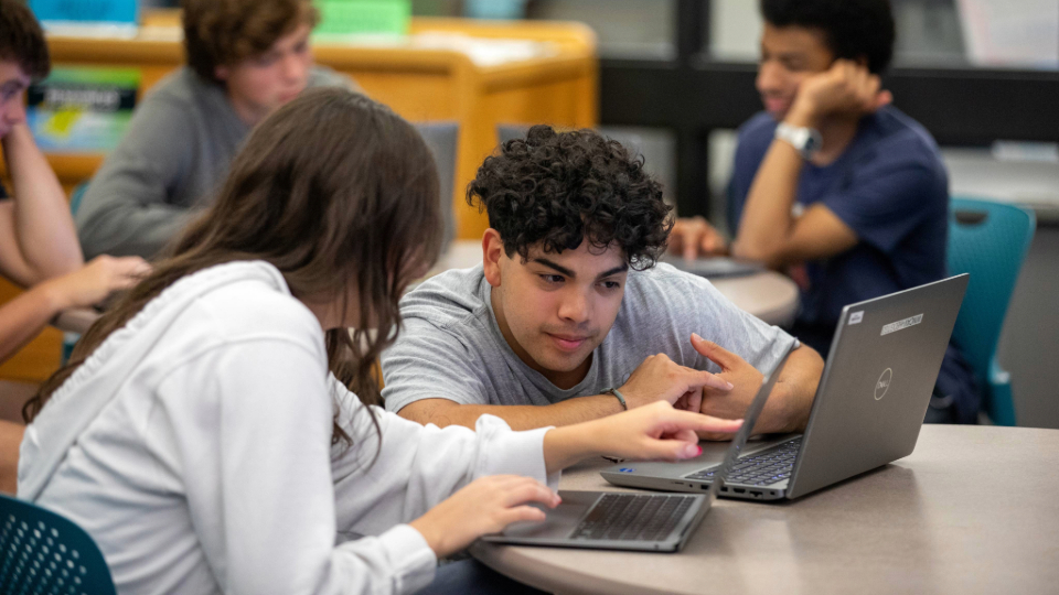 Students studying together at a table during class