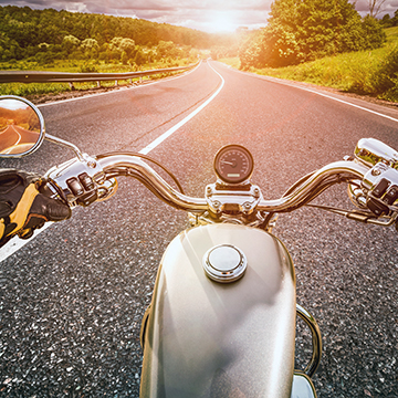A view of the road over the handlebars of a motorcycle.