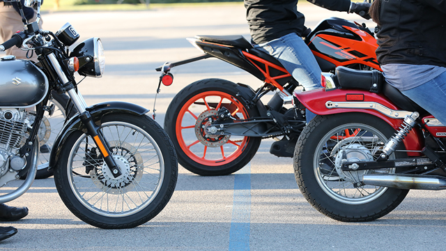 closely cropped photo showing the wheels of three motorcycles