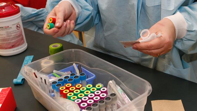 a pair of hands sort blood draw vials.