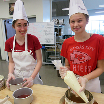 two teen girls practice making home made ice cream sandwiches