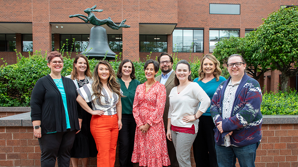 members of the communication studies faculty standing in a line and smiling at the viewer