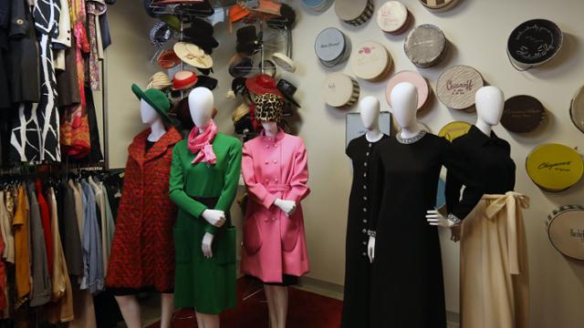 Several items from the collection are displayed on mannequins while other pieces hang on closet rods.
