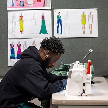 A JCCC fashion student uses a sewing machine.