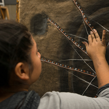 Student working on a painting in a FADS studio