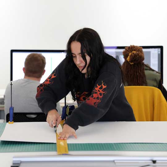 Student cutting mats in digital photography studio